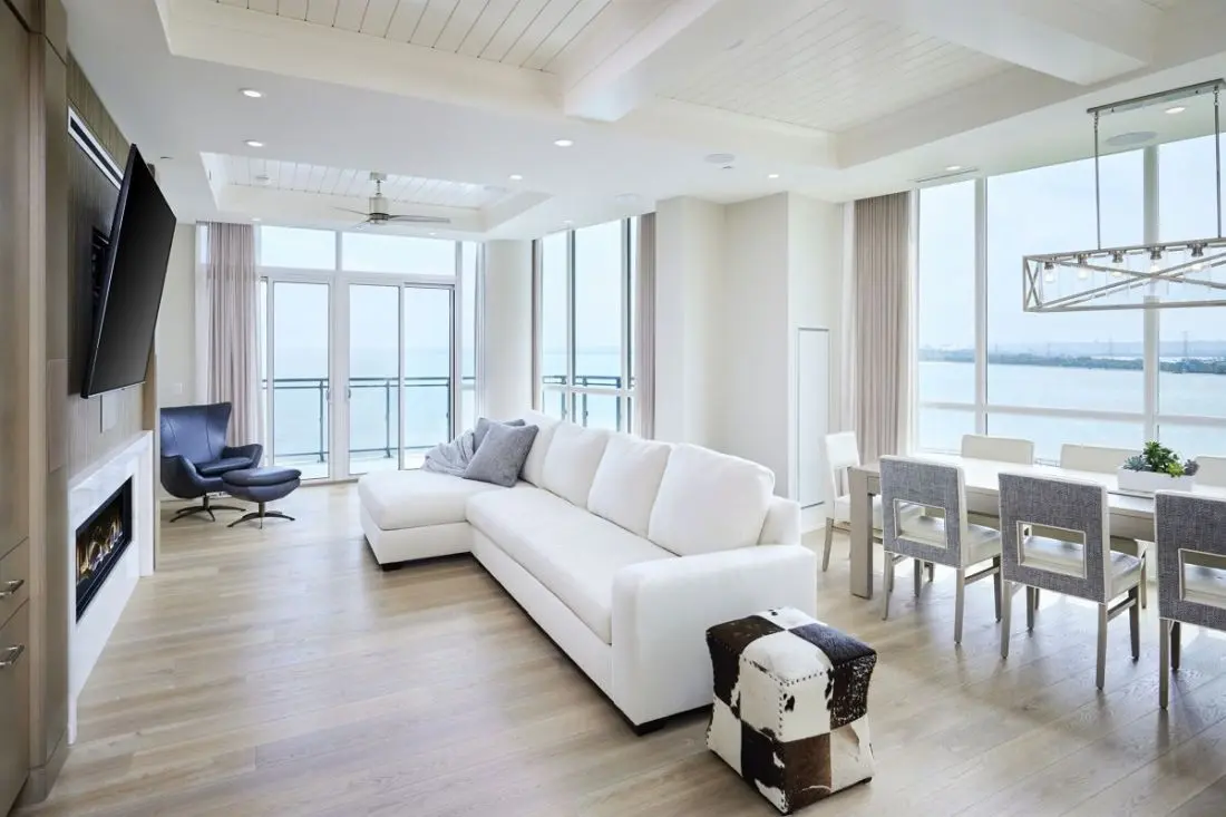 Penthouse living room with custom wood millwork and cabinetry by Homestead Woodworks, offering a modern, spacious design with ocean views